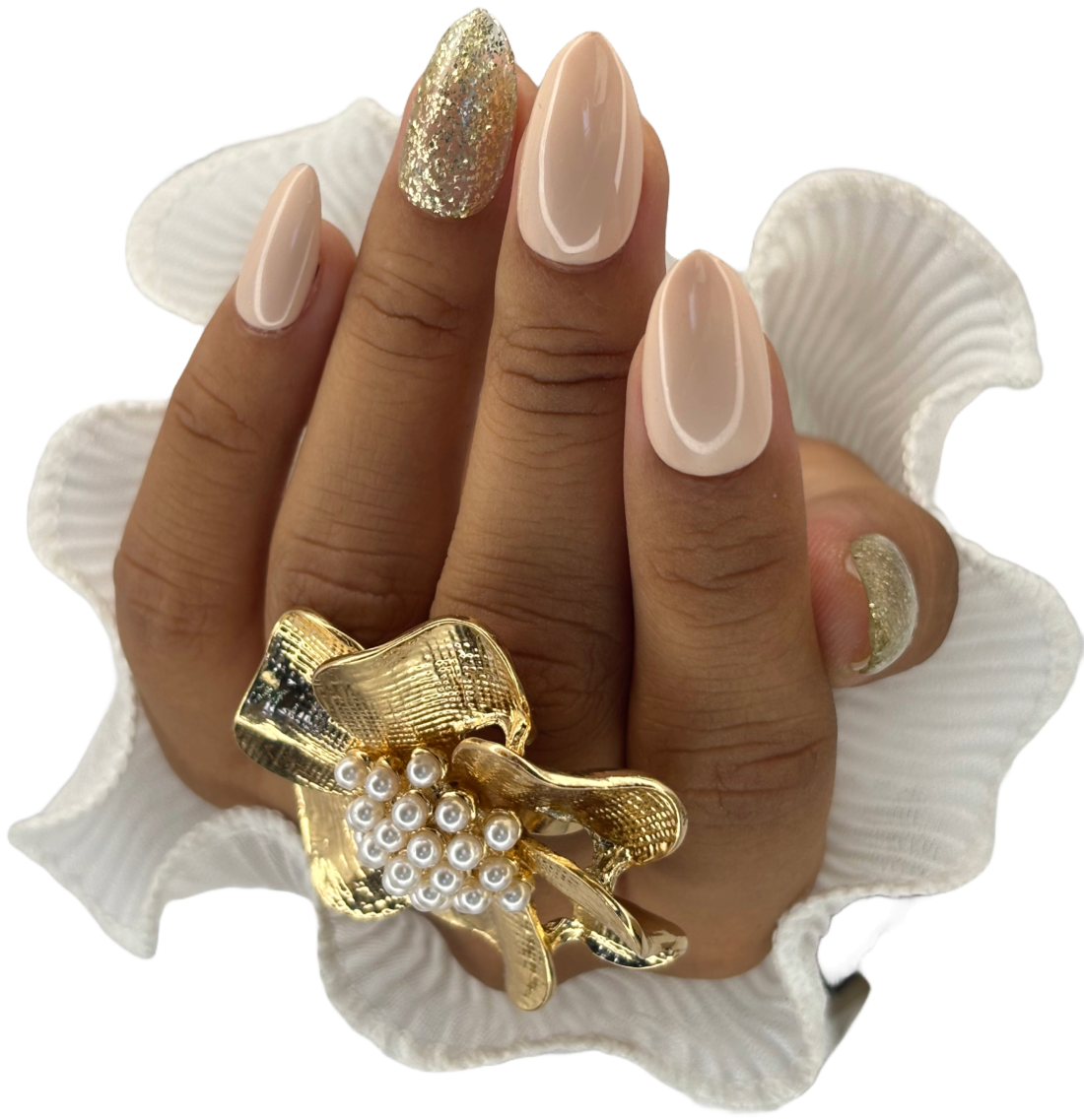 Main avec press-on nude, paillettes dorées et bague fleur